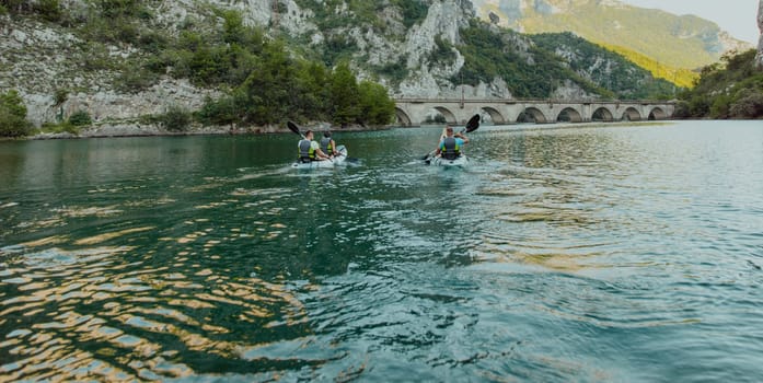 A group of friends enjoying having fun and kayaking while exploring the calm river, surrounding forest and large natural river canyons.