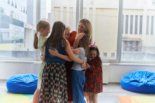 A child hugging a teacher in a modern kindergarten. High quality photo