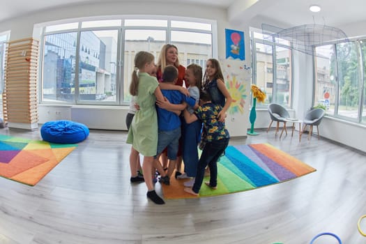 A child hugging a teacher in a modern kindergarten. High quality photo