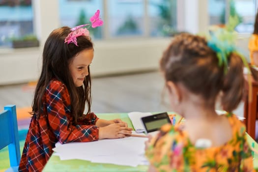 Creative kids during an art class in a daycare center or elementary school classroom drawing with female teacher