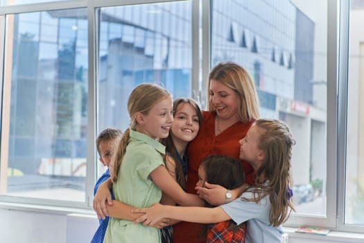 A child hugging a teacher in a modern kindergarten. High quality photo