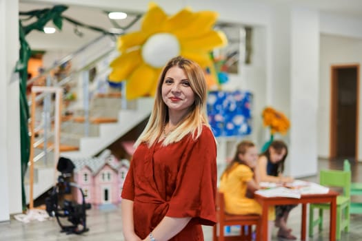 Portrait of a teacher in a preschool institution, in the background of the classrooms. High quality photo