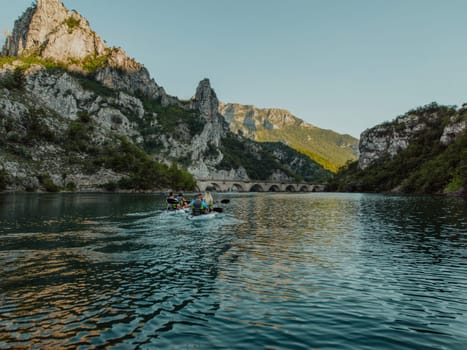 A group of friends enjoying having fun and kayaking while exploring the calm river, surrounding forest and large natural river canyons.