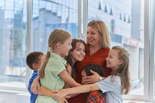 A child hugging a teacher in a modern kindergarten. High quality photo