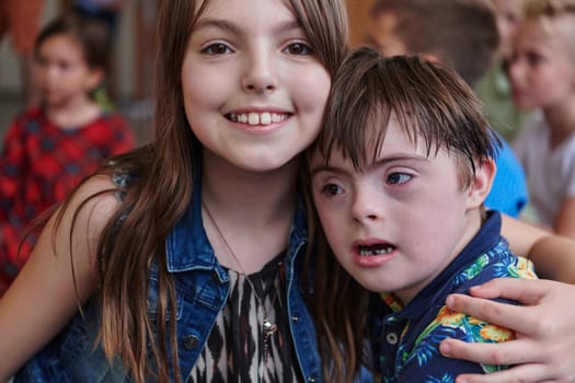 A girl and a boy with Down's syndrome in each other's arms spend time together in a preschool institution.