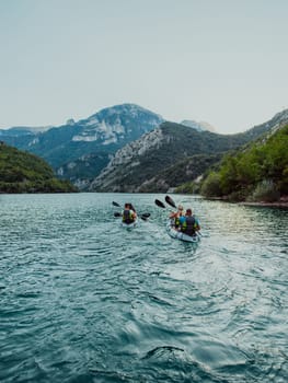 A group of friends enjoying fun and kayaking exploring the calm river, surrounding forest and large natural river canyons during an idyllic sunset