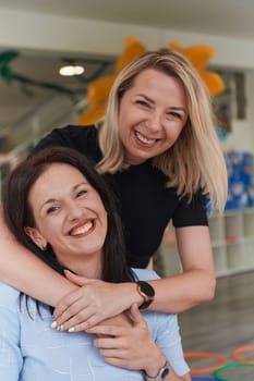 Two women share a heartfelt embrace while at a preschool, showcasing the nurturing and supportive environment for learning and growth.