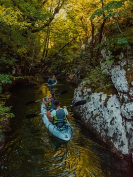 A young couple enjoying an idyllic kayak ride in the middle of a beautiful river surrounded by forest greenery.