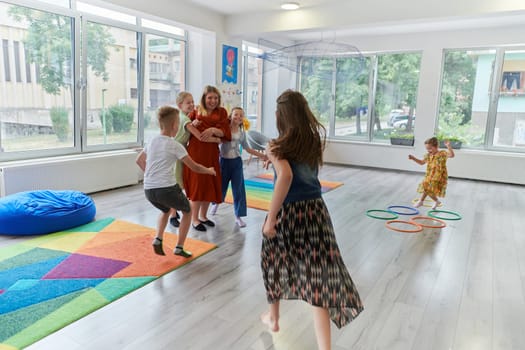 A child hugging a teacher in a modern kindergarten. High quality photo