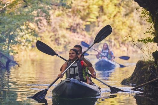 A group of friends enjoying having fun and kayaking while exploring the calm river, surrounding forest and large natural river canyons.