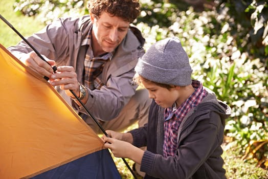 Dad, kid and set up tent for camping outdoor in nature on vacation while bonding in summer. Father, boy and preparing campsite, learning and helping in forest for travel, education and holiday