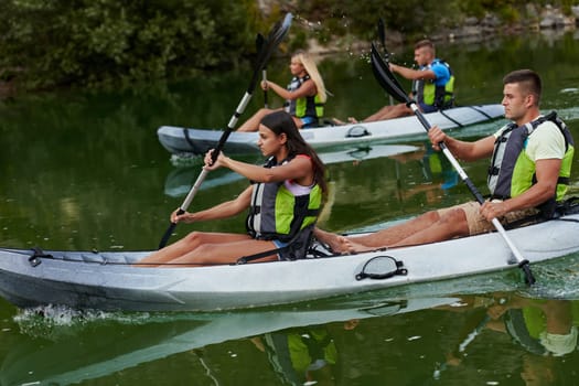 A group of friends enjoying having fun and kayaking while exploring the calm river, surrounding forest and large natural river canyons.