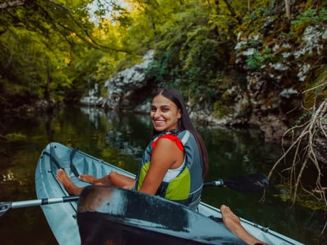 A smiling woman enjoying a relaxing kayak ride with a friend while exploring river canyons.