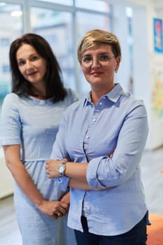 Portrait of a two teacher in a preschool institution, in the background of the classrooms.