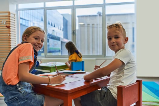 Cute girl and boy sit and draw together in preschool institution. High quality photo