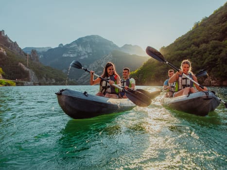 A group of friends enjoying fun and kayaking exploring the calm river, surrounding forest and large natural river canyons during an idyllic sunset