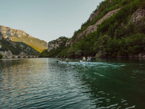 A group of friends enjoying having fun and kayaking while exploring the calm river, surrounding forest and large natural river canyons.