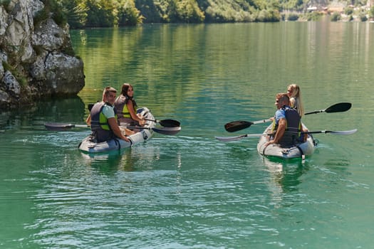 A group of friends enjoying having fun and kayaking while exploring the calm river, surrounding forest and large natural river canyons.