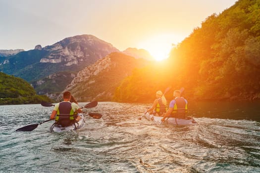 A group of friends enjoying fun and kayaking exploring the calm river, surrounding forest and large natural river canyons during an idyllic sunset