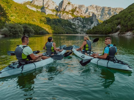 A group of friends enjoying having fun and kayaking while exploring the calm river, surrounding forest and large natural river canyons.