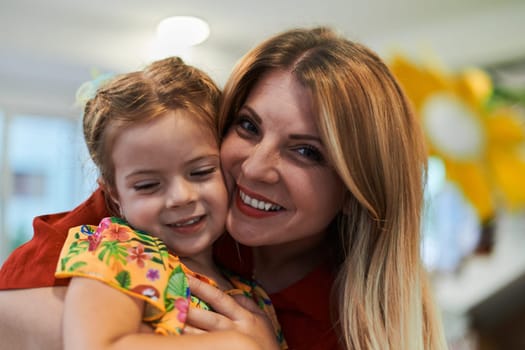 A cute little girl kissing and hugs her mother in preschool. High quality photo