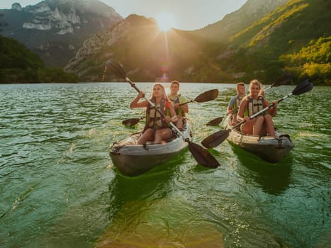 A group of friends enjoying fun and kayaking exploring the calm river, surrounding forest and large natural river canyons during an idyllic sunset