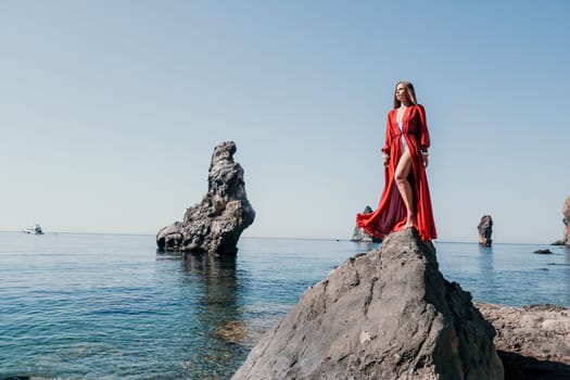 Woman travel sea. Happy tourist taking picture outdoors for memories. Woman traveler looks at the edge of the cliff on the sea bay of mountains, sharing travel adventure journey.