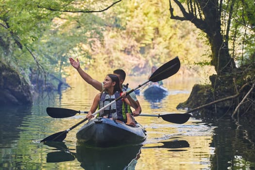 A group of friends enjoying having fun and kayaking while exploring the calm river, surrounding forest and large natural river canyons.