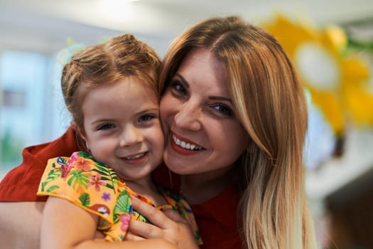 A cute little girl kissing and hugs her mother in preschool. High quality photo