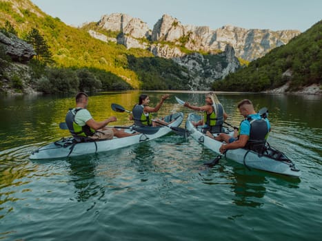 A group of friends enjoying having fun and kayaking while exploring the calm river, surrounding forest and large natural river canyons.