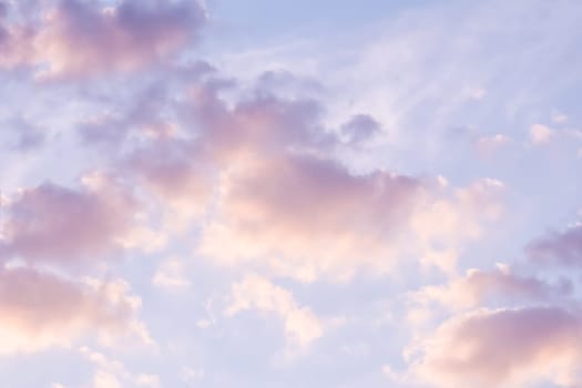 Background of blue sky with pale pink clouds at sunset