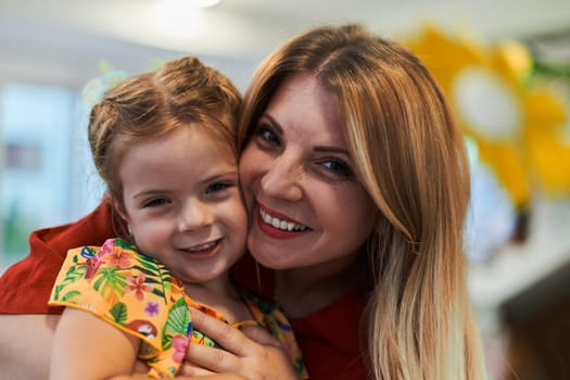 A cute little girl kissing and hugs her mother in preschool. High quality photo