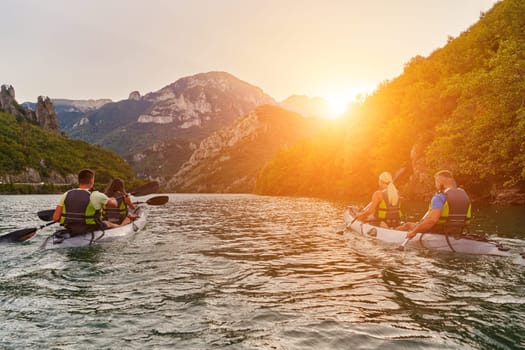 A group of friends enjoying fun and kayaking exploring the calm river, surrounding forest and large natural river canyons during an idyllic sunset