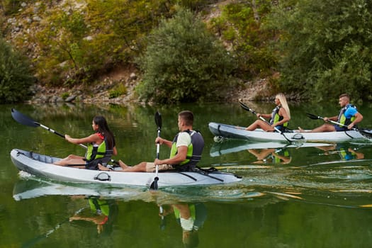 A group of friends enjoying having fun and kayaking while exploring the calm river, surrounding forest and large natural river canyons.