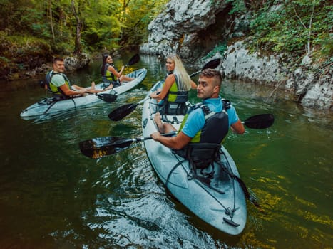 A group of friends enjoying having fun and kayaking while exploring the calm river, surrounding forest and large natural river canyons.