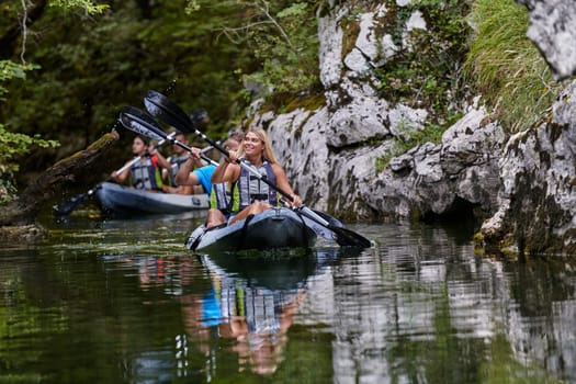 A group of friends enjoying having fun and kayaking while exploring the calm river, surrounding forest and large natural river canyons.