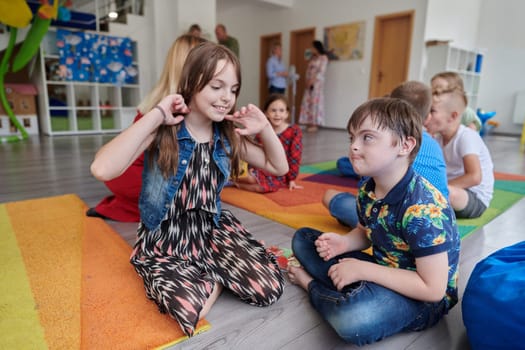 A girl and a boy with Down's syndrome in each other's arms spend time together in a preschool institution.