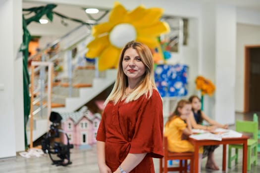 Portrait of a teacher in a preschool institution, in the background of the classrooms. High quality photo