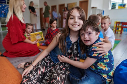 A girl and a boy with Down's syndrome in each other's arms spend time together in a preschool institution.