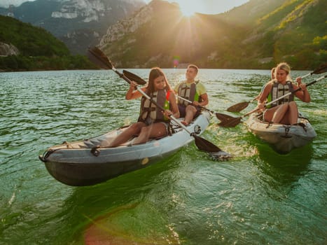 A group of friends enjoying fun and kayaking exploring the calm river, surrounding forest and large natural river canyons during an idyllic sunset