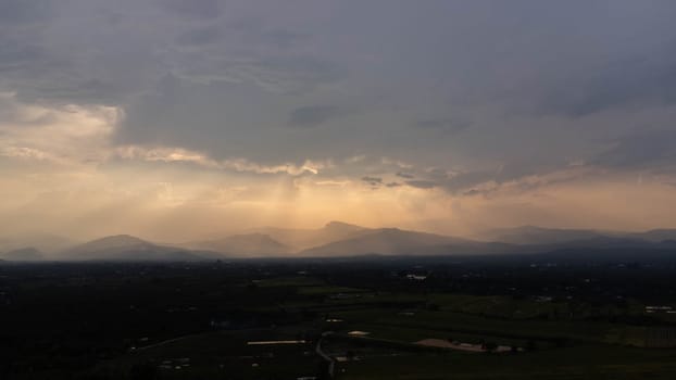 Mountains and beautiful clouds under sunset sky. Beautiful mountain landscape with golden sky.