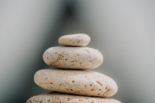 Pyramid stones on the seashore with warm sunset on the sea background. Happy holidays. Pebble beach, calm sea, travel destination. Concept of happy vacation on the sea, meditation, spa, calmness.