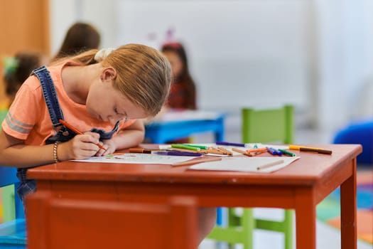 Creative kids sitting in a preschool institution, draw and have fun while they get an education. High quality photo