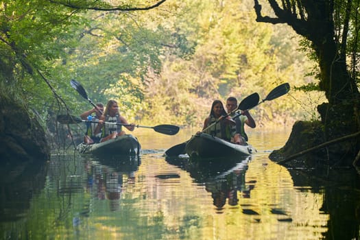 A group of friends enjoying having fun and kayaking while exploring the calm river, surrounding forest and large natural river canyons.