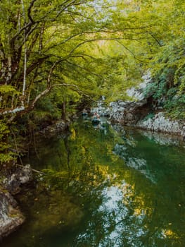 A group of friends enjoying having fun and kayaking while exploring the calm river, surrounding forest and large natural river canyons.