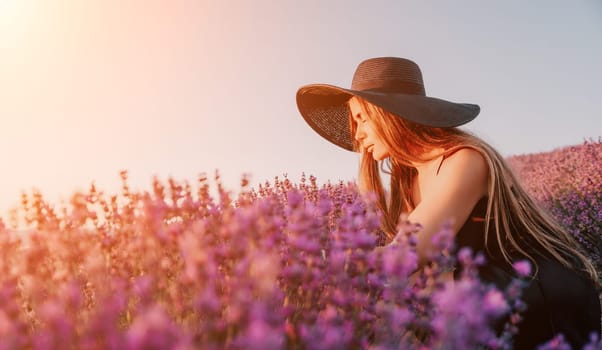 Close up portrait of young beautiful woman in a white dress and a hat is walking in the lavender field and smelling lavender bouquet.