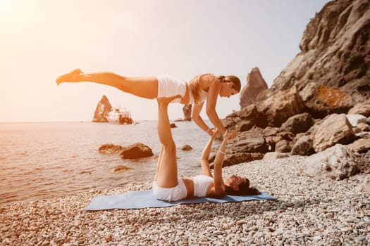 Woman sea yoga. Back view of free calm happy satisfied woman with long hair standing on top rock with yoga position against of sky by the sea. Healthy lifestyle outdoors in nature, fitness concept.