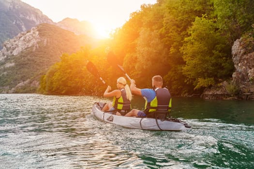 A group of friends enjoying fun and kayaking exploring the calm river, surrounding forest and large natural river canyons during an idyllic sunset