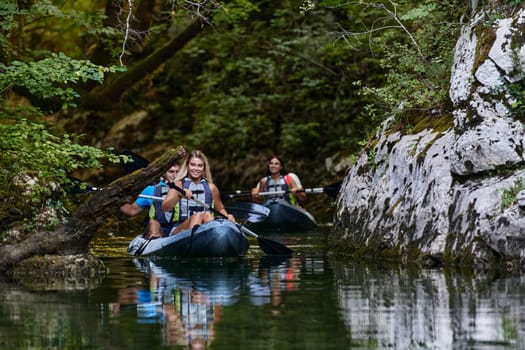 A group of friends enjoying having fun and kayaking while exploring the calm river, surrounding forest and large natural river canyons.