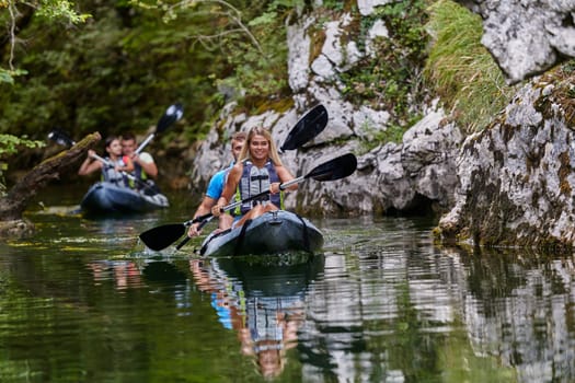 A group of friends enjoying having fun and kayaking while exploring the calm river, surrounding forest and large natural river canyons.